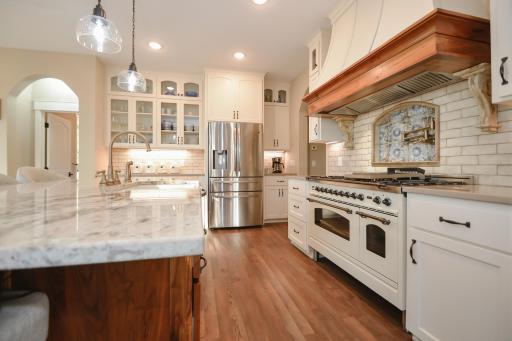 The gourmet kitchen showcases Schlangen's Custom black walnut island and painted cabinetry, quartz countertops, granite island, professional-grade appliances, and an Italian ILIVE oven.