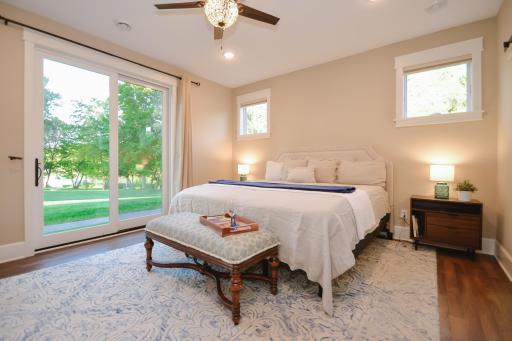 The luxurious lakeside primary suite offers patio access, spa-inspired bath with steam shower, and a secure walk-in closet/storm shelter.