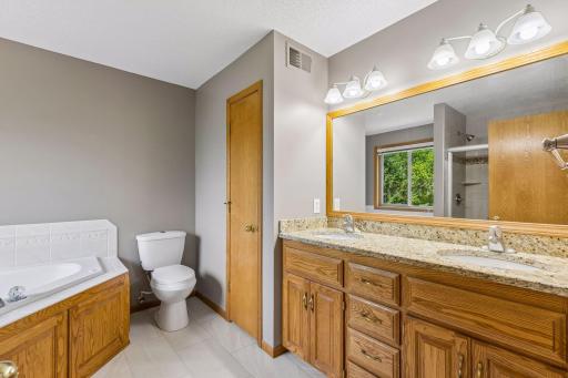 Refined Primary Ensuite with Granite Counters, two sinks, tile flooring, walk in shower, & Soaking Tub