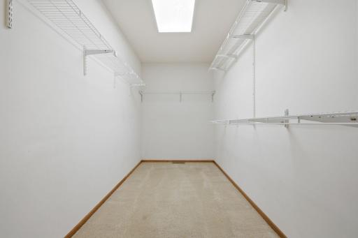 A spacious primary walk-in closet designed with ample room for wardrobe organization and storage.