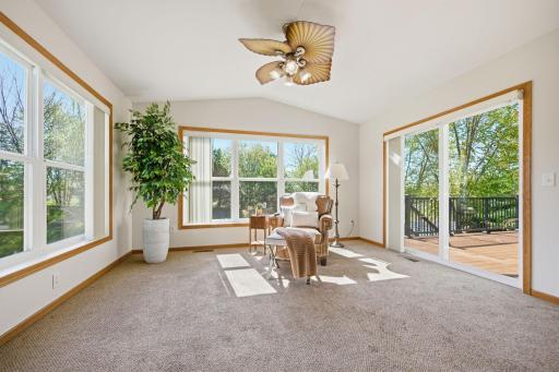 The four-season porch offers a bright and airy retreat with a vaulted ceiling and sliding glass doors that provide seamless access to the newly completed maintenance-free deck