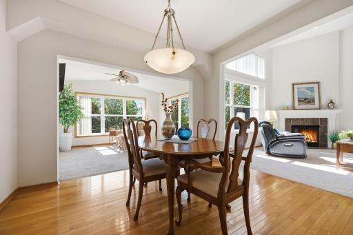 The informal dining room offers a lovely view into the four-season porch and family room, where abundant charm, quality details, and soaring vaulted ceilings create a warm and inviting atmosphere.