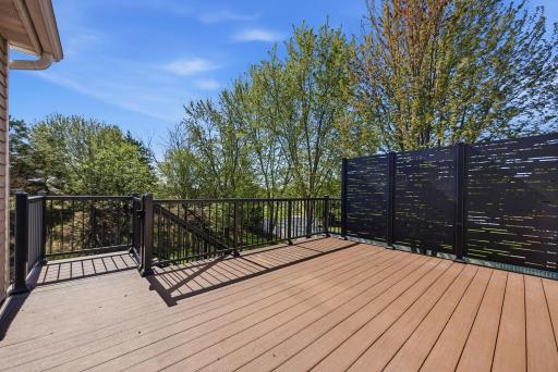 The newly constructed 14' x 16' backyard deck offers a maintenance-free outdoor living space complete with a privacy wall and an under-deck drainage system, allowing the patio below to remain dry and functional throughout the year.