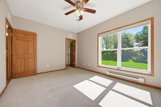 Another lower-level bedroom offers generous 11' x 14' dimensions, a walk-in closet, and large windows overlooking the backyard. This room is beautifully maintained, with immaculate carpeting, well-kept flooring, and neutral paint throughout.