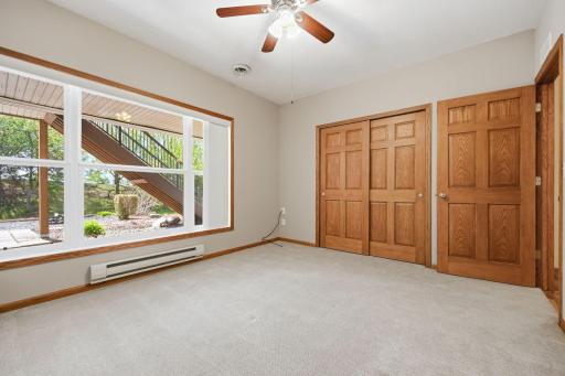 This bedroom features generous closet space and expansive daylight windows overlooking the backyard, while the lower level offers independently controlled zone heating for personalized comfort.