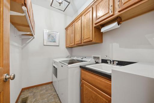 Conveniently located on the main floor, this spacious laundry room offers abundant storage, dedicated hanging space, & a large sink with storage underneath. It also features a brand-new washer and dryer and is one of two laundry rooms in the home.