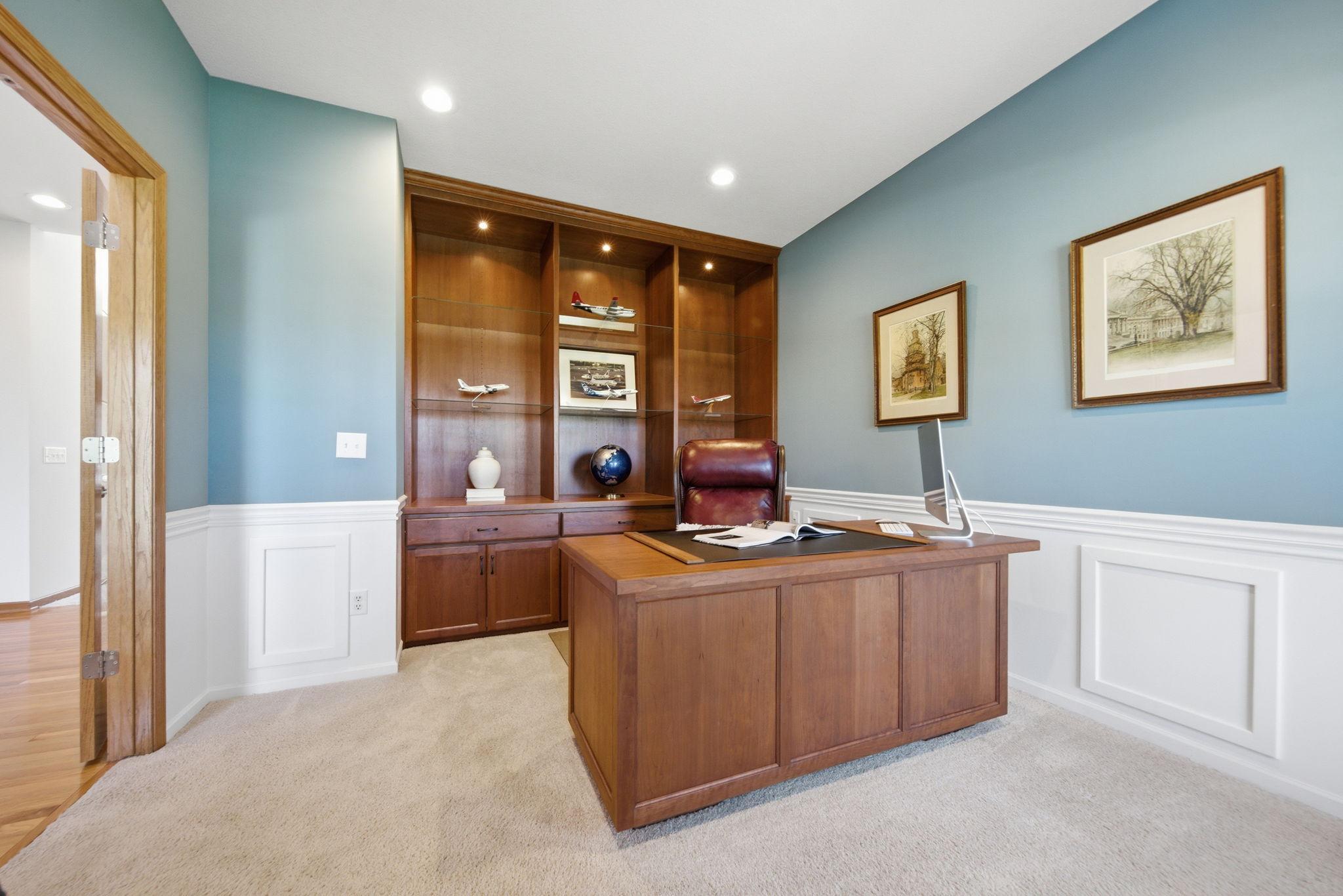 The custom-designed office features a beautifully crafted built-in desk with soft-close drawers, complemented by windows in excellent condition. This refined and functional space is ideal for working from home in comfort and style.