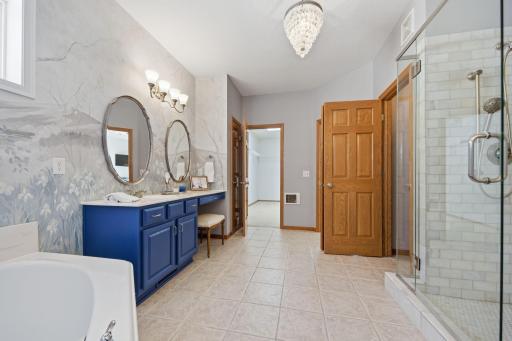 Primary bathroom professionally painted by a local artist - the walls were painted to reflect a nature scene - A serene retreat for soaking in tub, complemented by 2 separate vanity areas offering generous counter & cabinetry space (new shower area.)