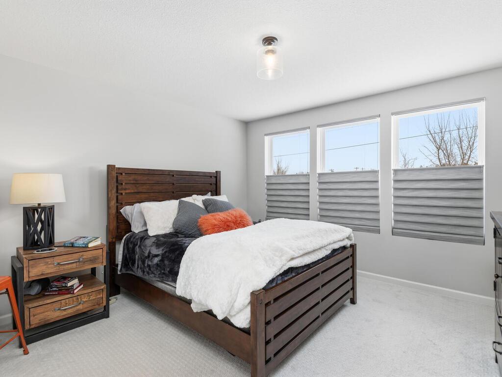 Spacious primary bedroom with custom window treatments!