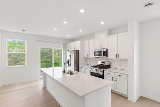 At the focal point of this modern kitchen is a quartz-topped center island to add bar-style seating, complemented by extensive cabinetry room and all-new stainless steel appliances to craft delicious meals.