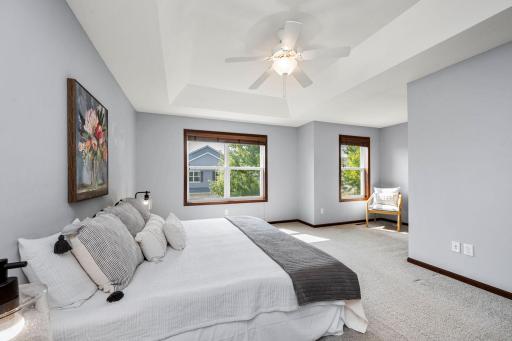 Relax and unwind in the spacious primary suite complete with tray ceiling, cozy reading nook, and walk-in closet.