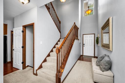 Impressive two-story foyer with an open staircase, oversized window, and abundant natural light creates a warm and memorable first impression.