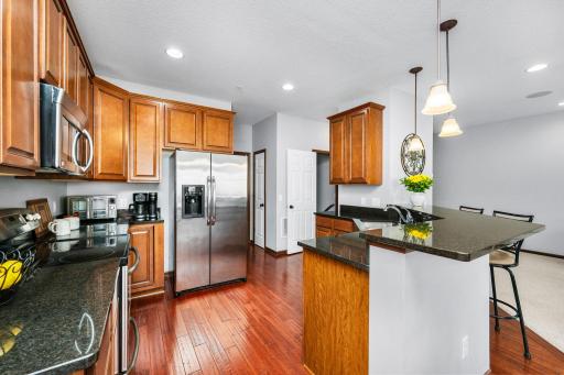 This spacious kitchen offers style and function featuring granite countertops, stainless steel appliances, and abundant cabinetry.