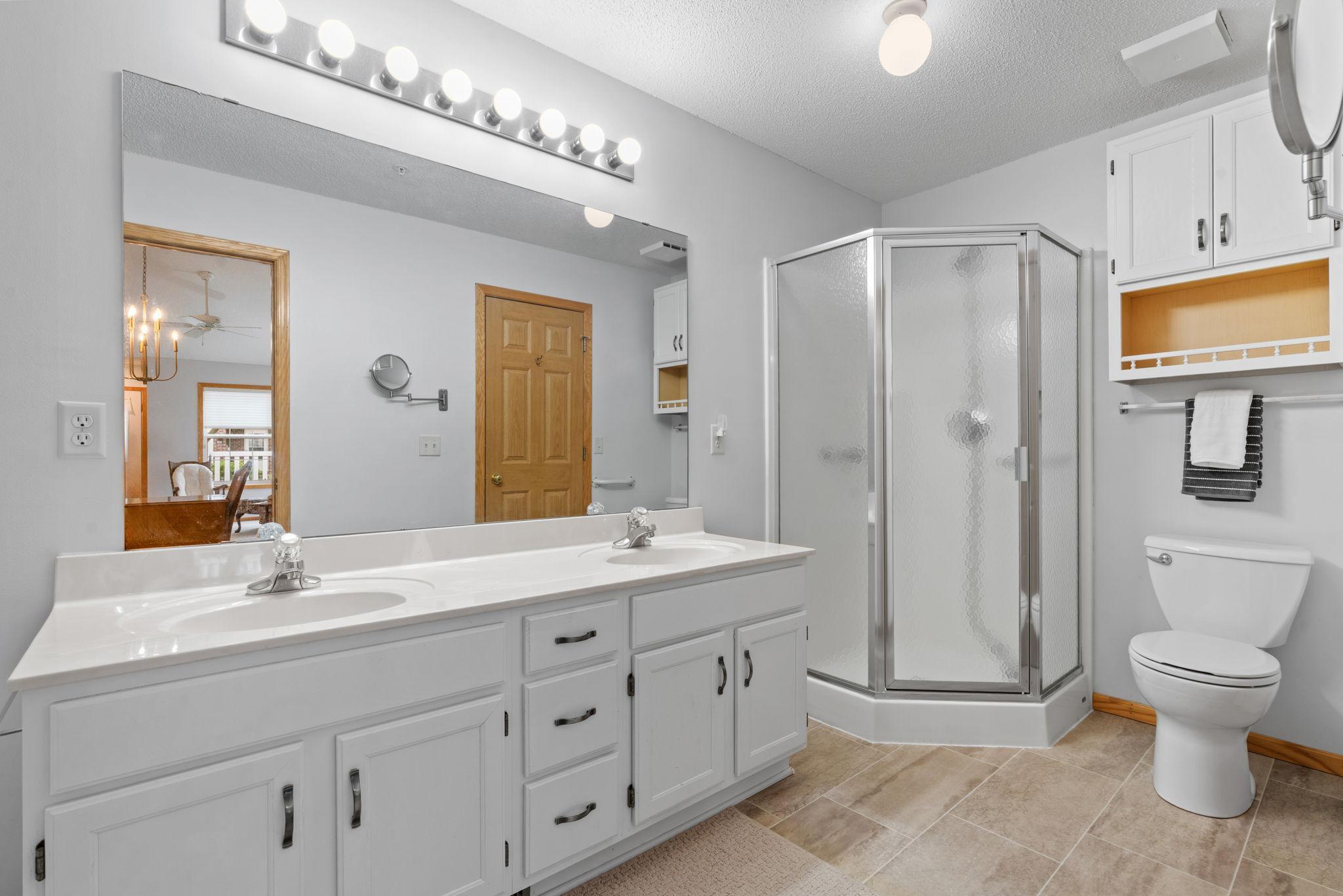 Luxurious bath features double vanity, shower & cabinetry