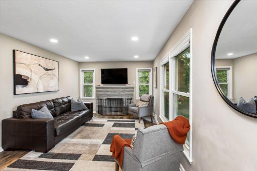 Walk into bright living room with fireplace as focal point