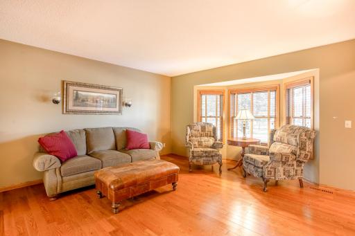 A bright bay window fills the formal living room with natural light, creating a warm and welcoming atmosphere.