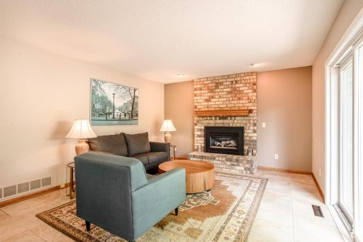 The warm brick fireplace creates a welcoming focal point in this comfortable family room.