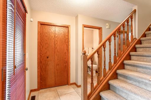 A welcoming foyer features a convenient main-level powder room and a staircase leading to the upper level.