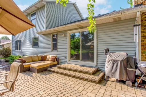 Enjoy seamless indoor-outdoor living on the spacious paver patio, complete with multiple seating areas for relaxing and entertaining.