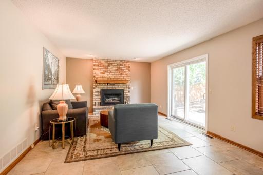 Gather around the cozy gas fireplace in the inviting family room, complete with patio access for seamless indoor-outdoor living.