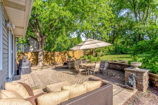 Enjoy seamless indoor-outdoor living on the spacious paver patio, complete with multiple seating areas for relaxing and entertaining.