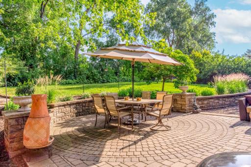Gather with family and friends on the expansive patio overlooking the beautifully landscaped yard and mature trees.