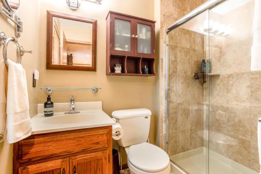 The updated en suite bathroom features a beautifully tiled walk-in shower with sleek glass doors.