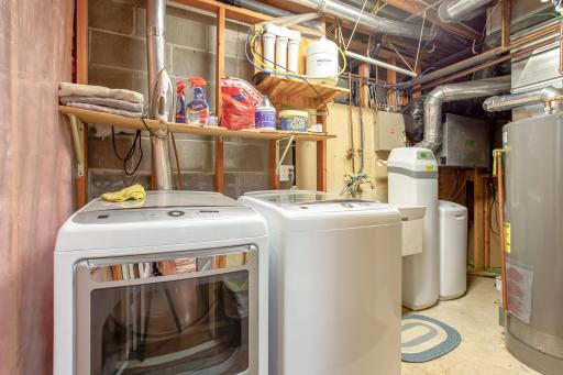 A functional utility and laundry room offers ample workspace while housing the home's mechanical systems, keeping everyday essentials organized and easily accessible.