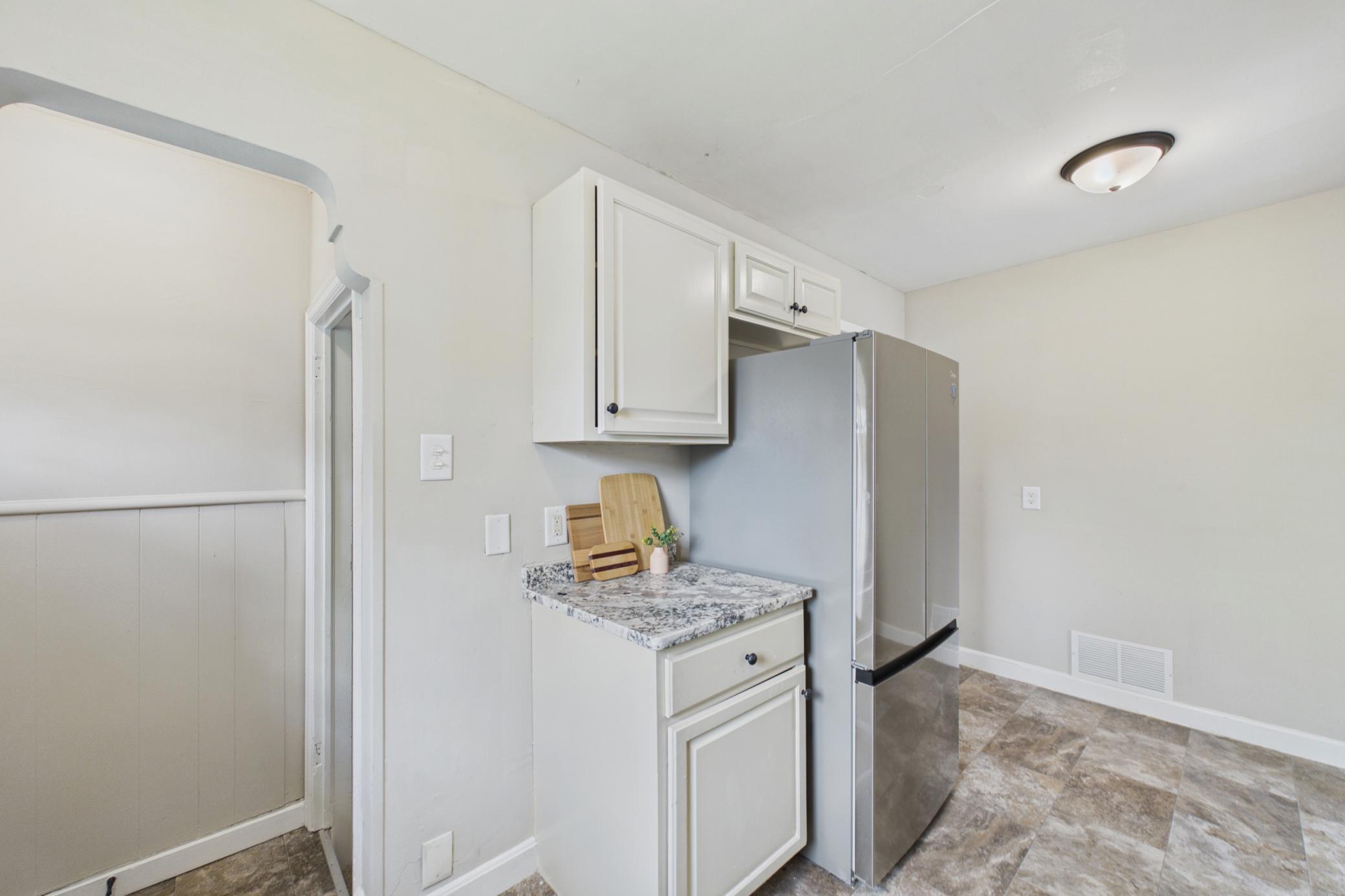 Kitchen with additional prep space and newer refrigerator.