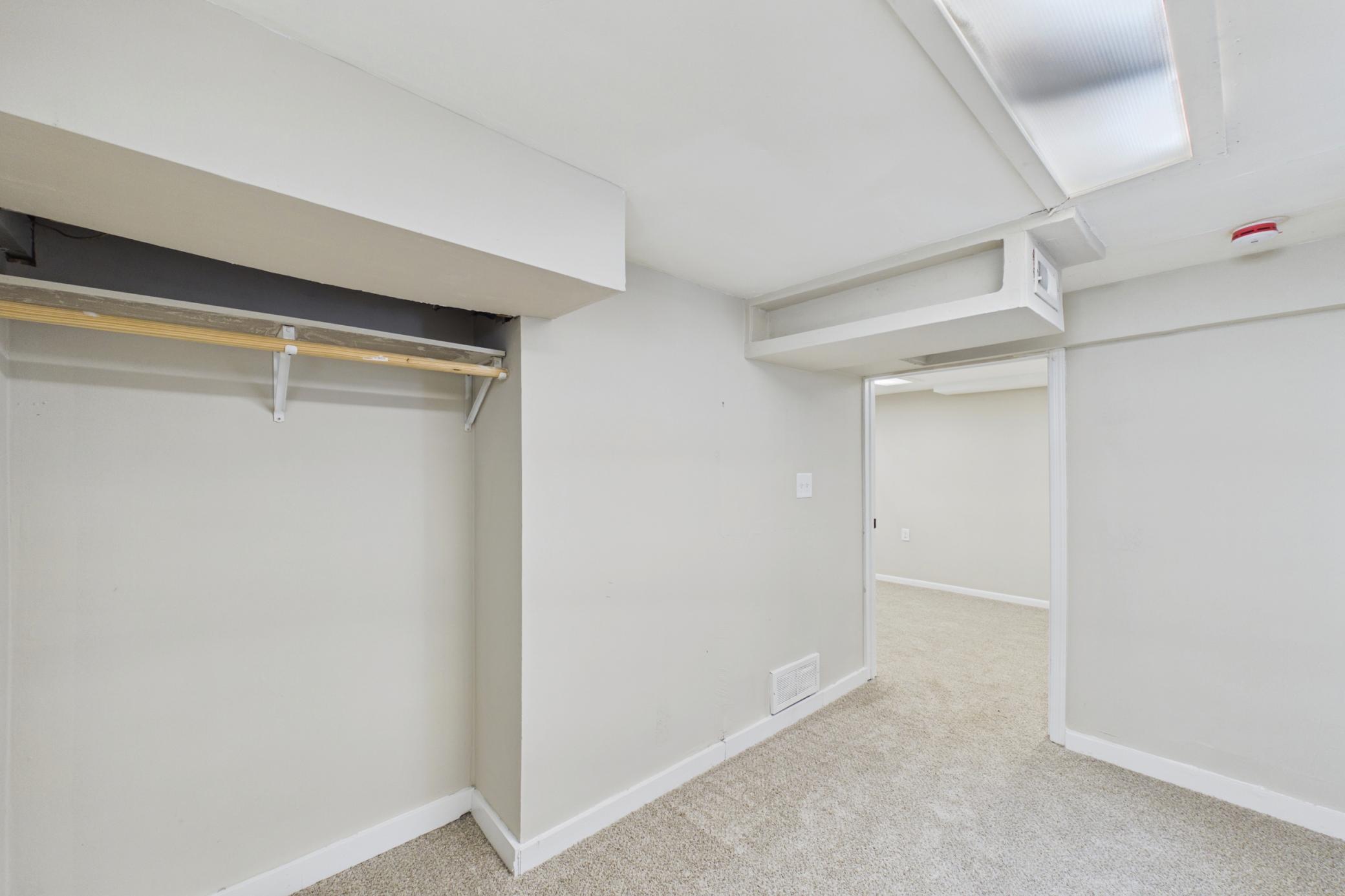 Lower level bedroom with closet and carpet flooring.