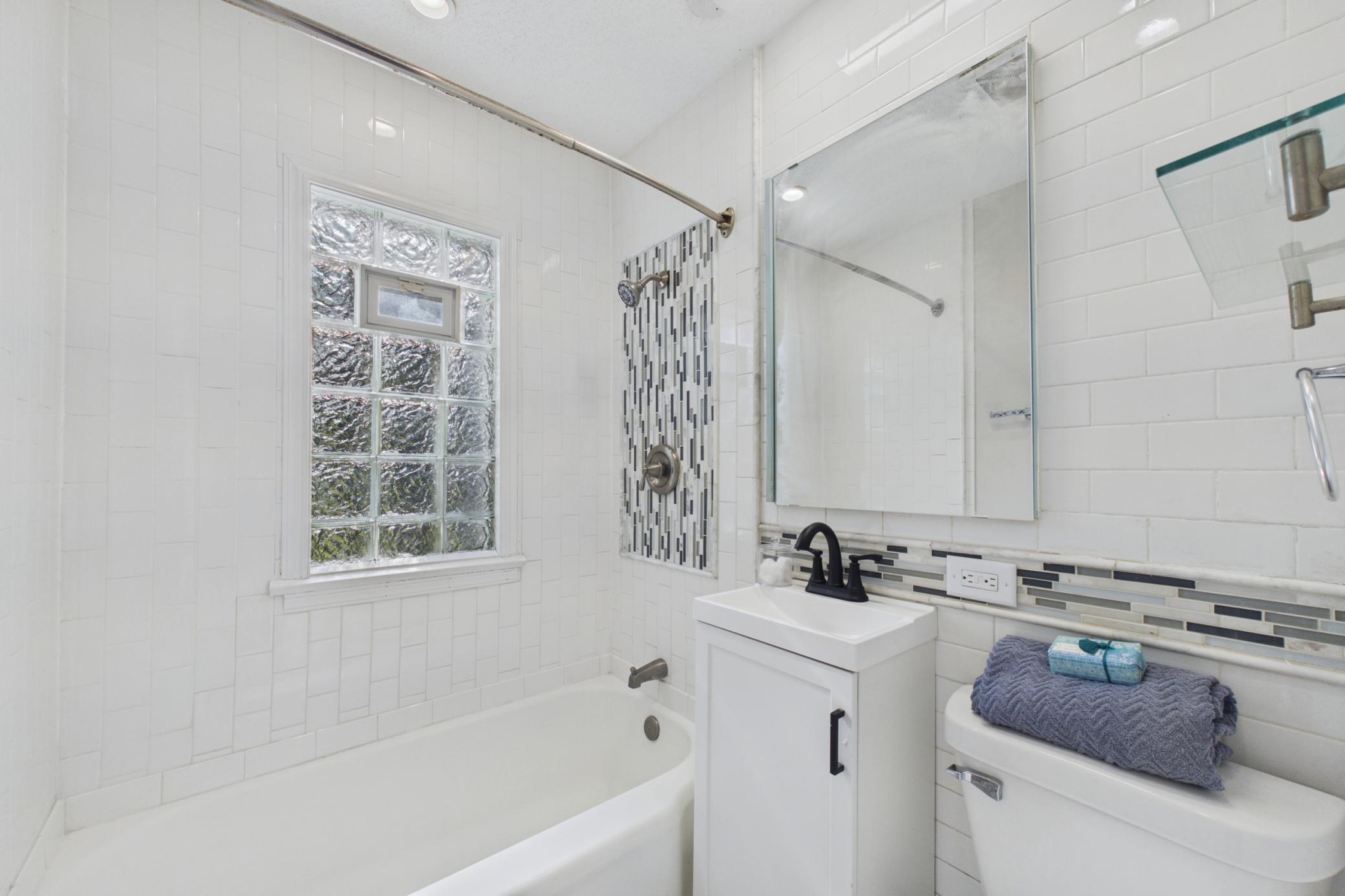 Updated full bathroom with tiled shower surround and modern fixtures.