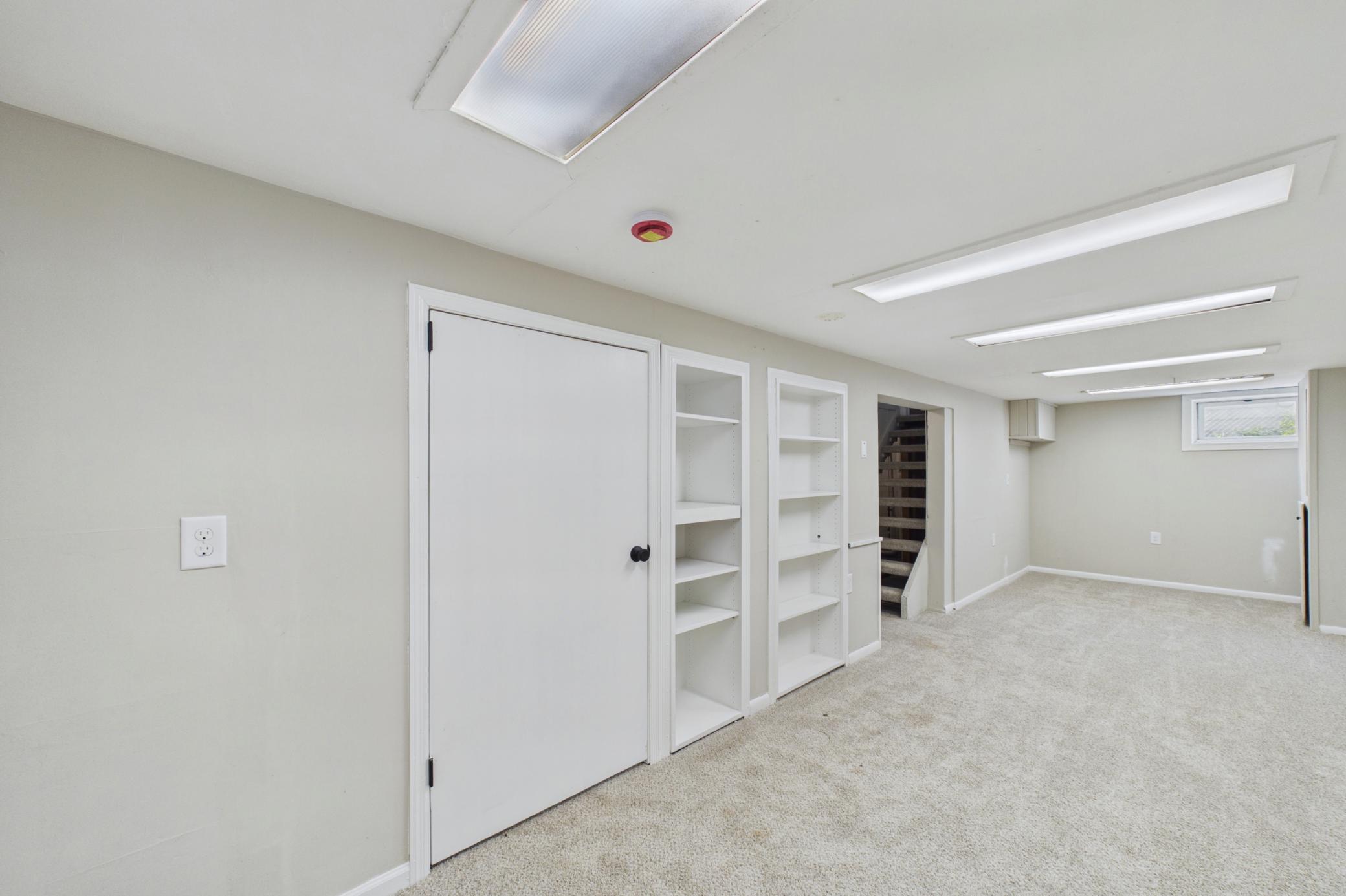 Spacious lower level with shelving and multiple-use layout.