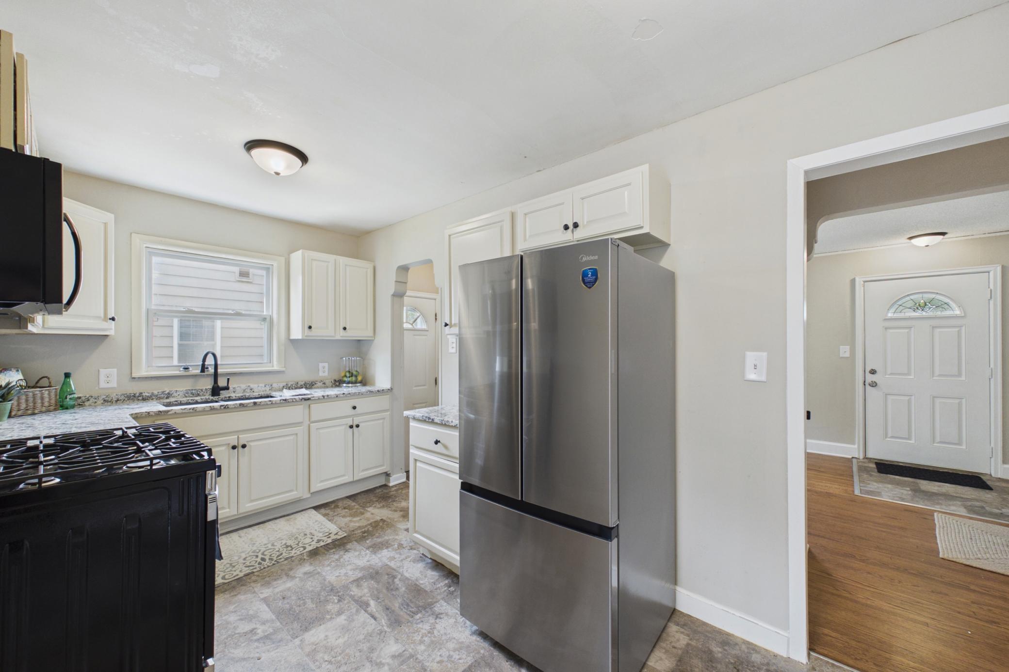 Kitchen with stainless steel appliances, updated countertops, and white cabinetry.