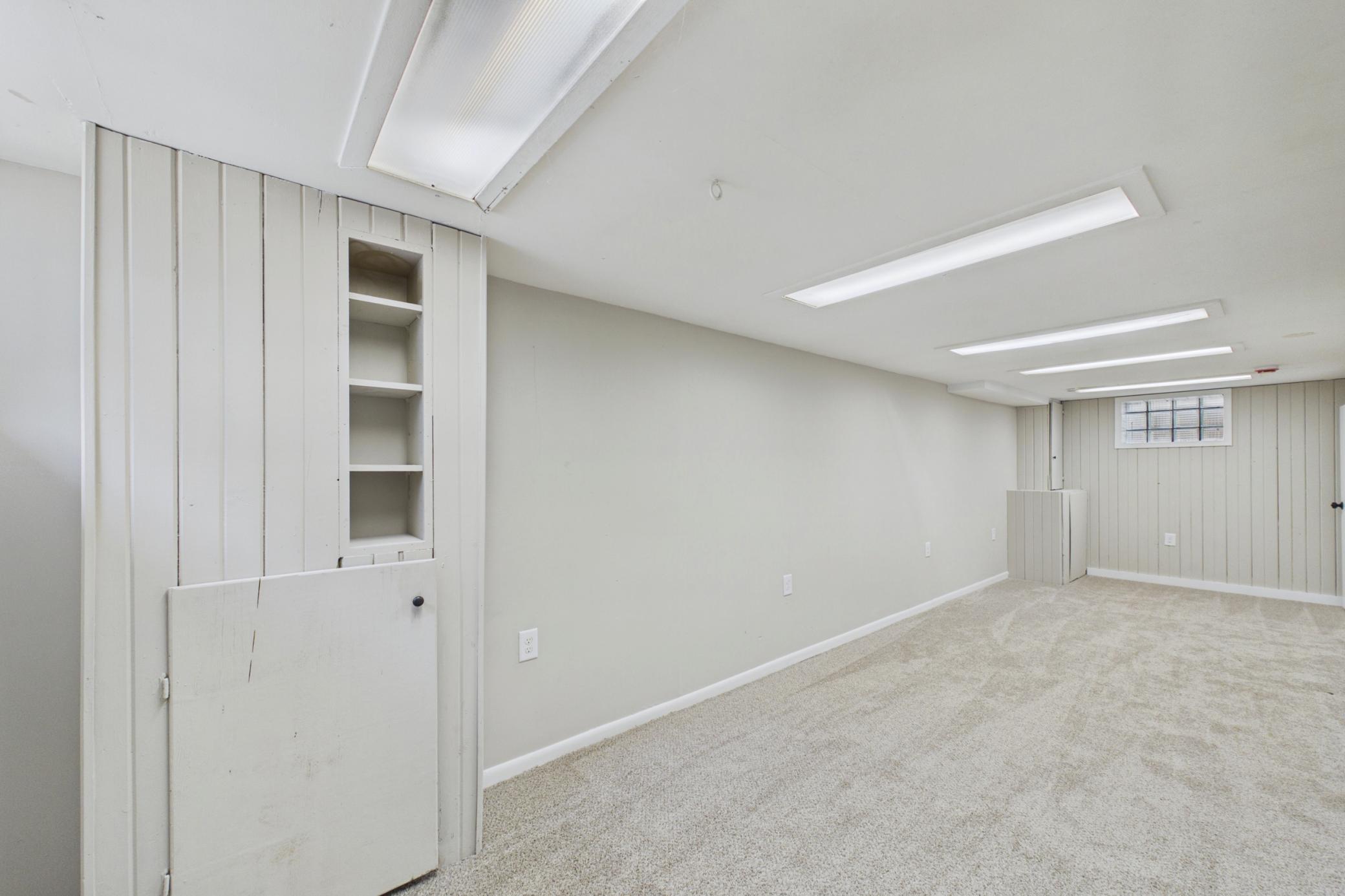 Finished lower level family room with built-in storage.