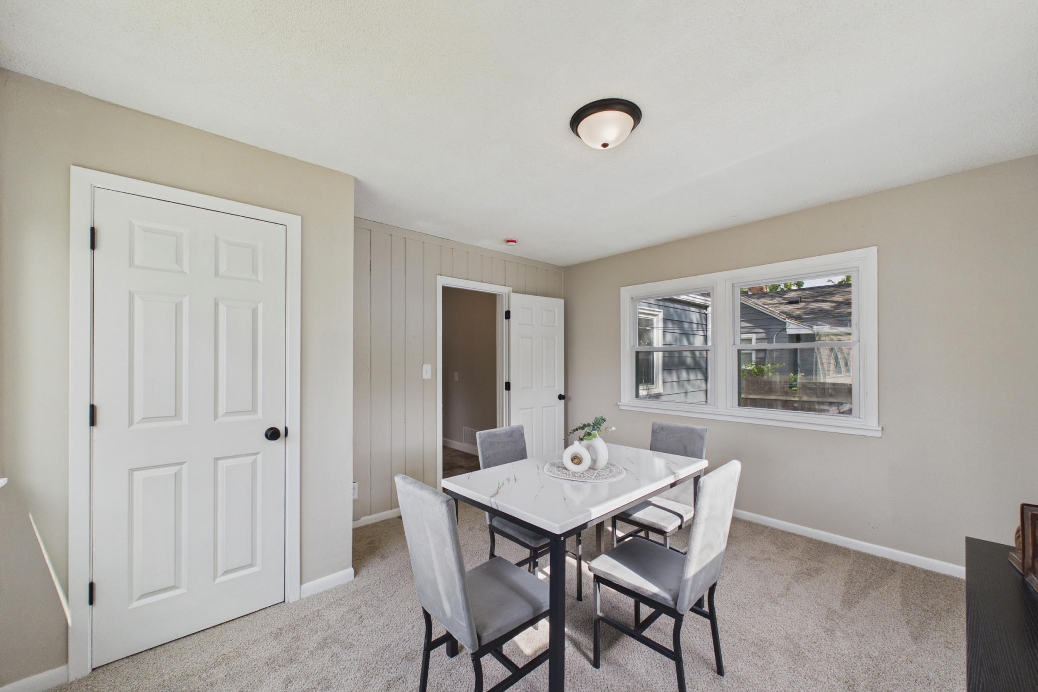 Dining space with access to kitchen and backyard views.