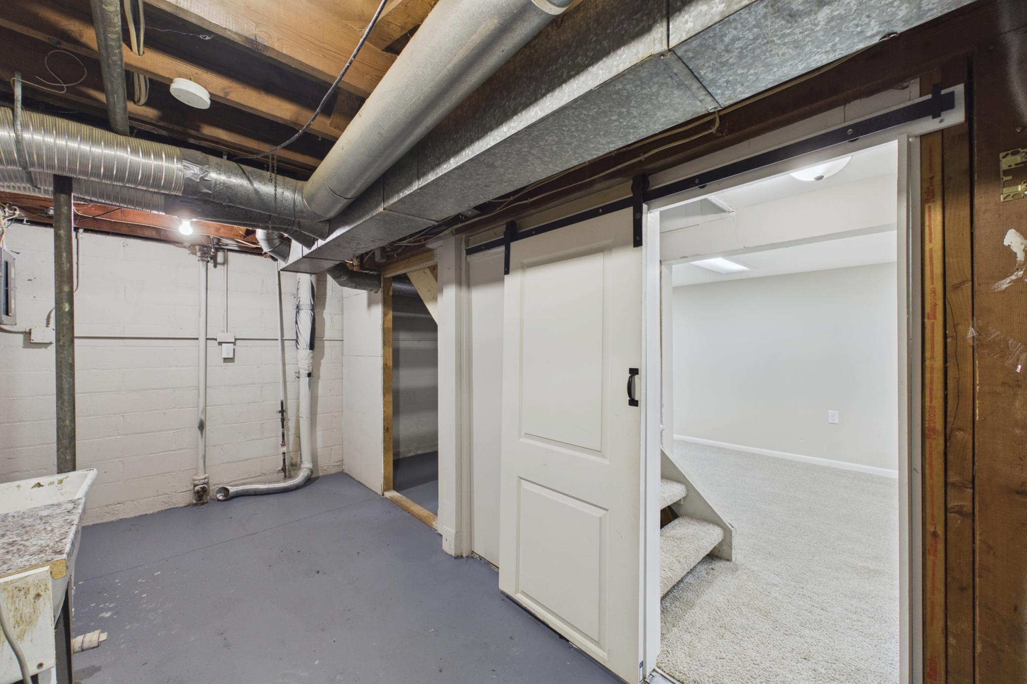 Lower level storage area with sliding barn door entry.