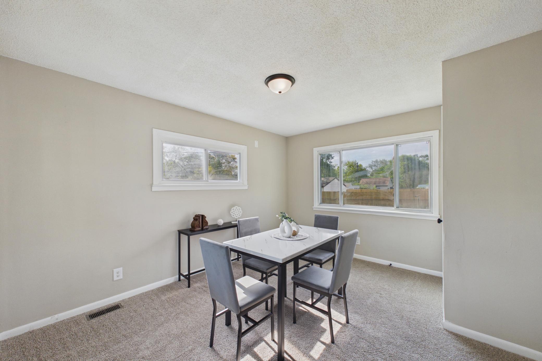 Dining area with large picture window and updated carpet.