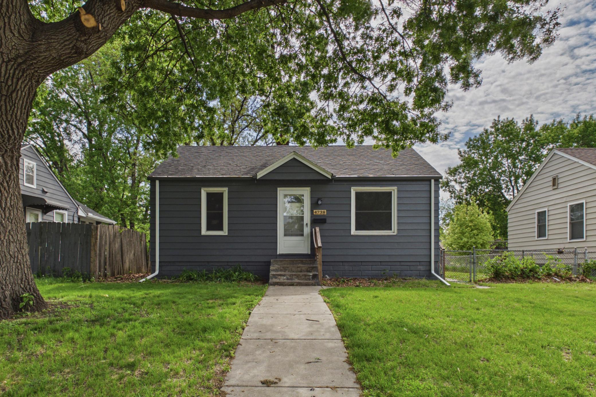 Front exterior with mature trees, spacious yard, and updated exterior finish.
