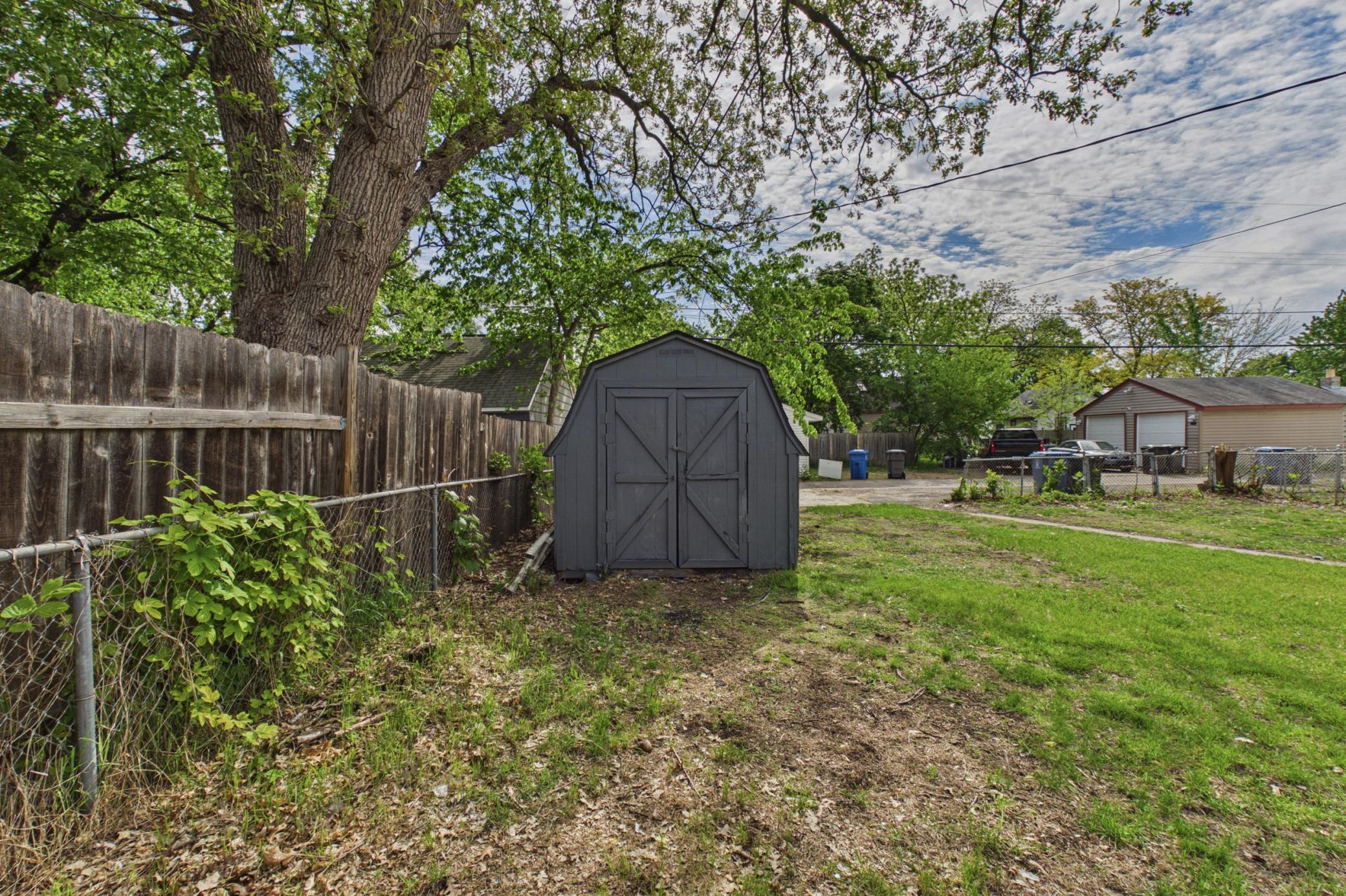 Backyard storage shed and fenced yard space.