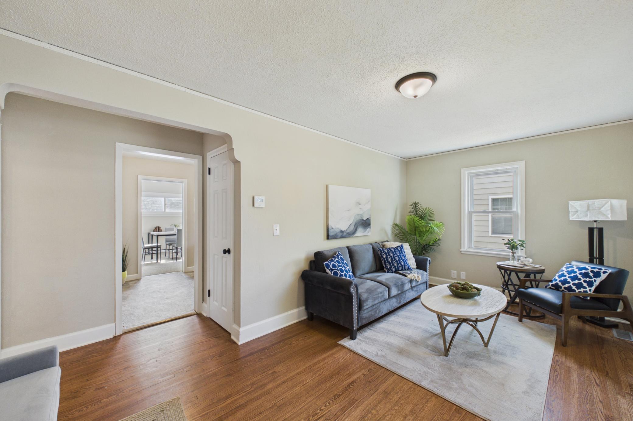 Living room with arched doorway and open flow to dining area.