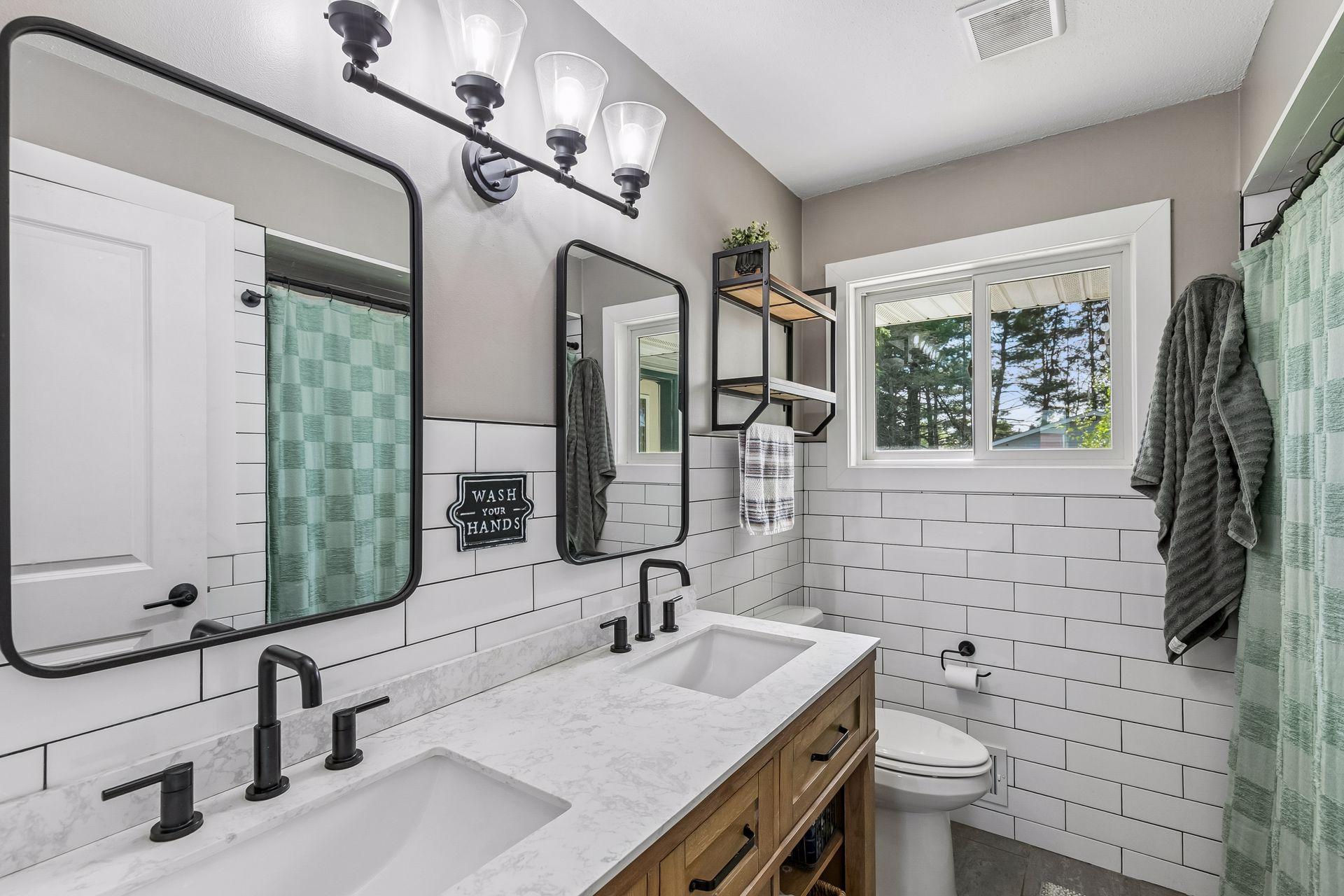 Main level full bathroom w/ double sink & beautiful tile work throughout.