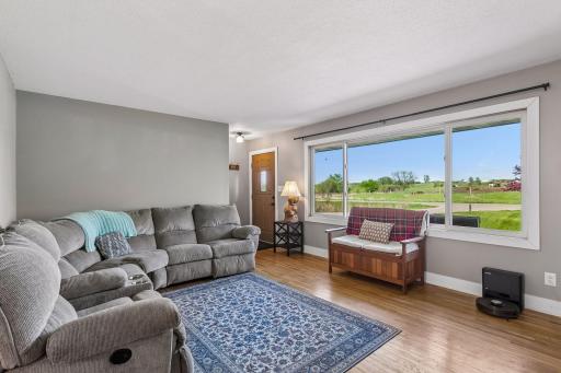 Main level living room w/ large window that brings in tons of natural light overlooking the front yard.