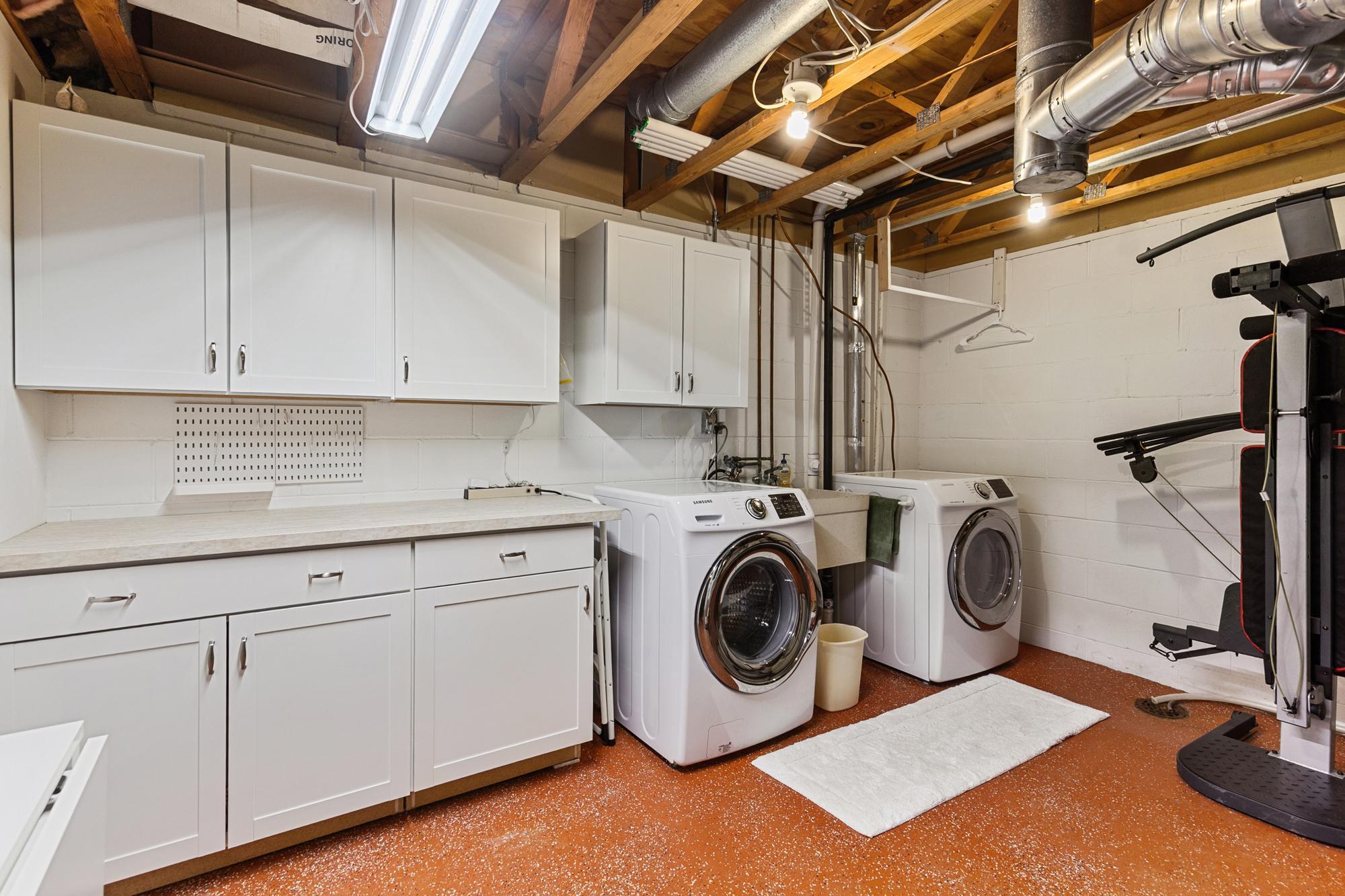 Laundry room complete with built-ins - all atop an epoxy flooring.