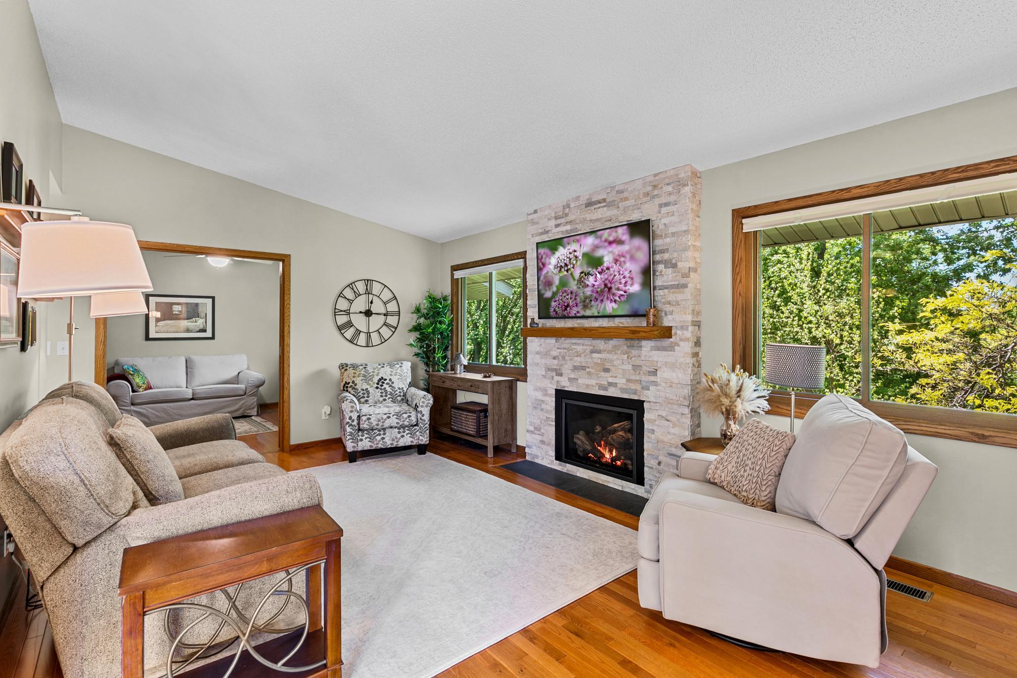 Main level Family room offers a neutral palate, gas burning fireplace and stunning views from each of it's south facing windows.