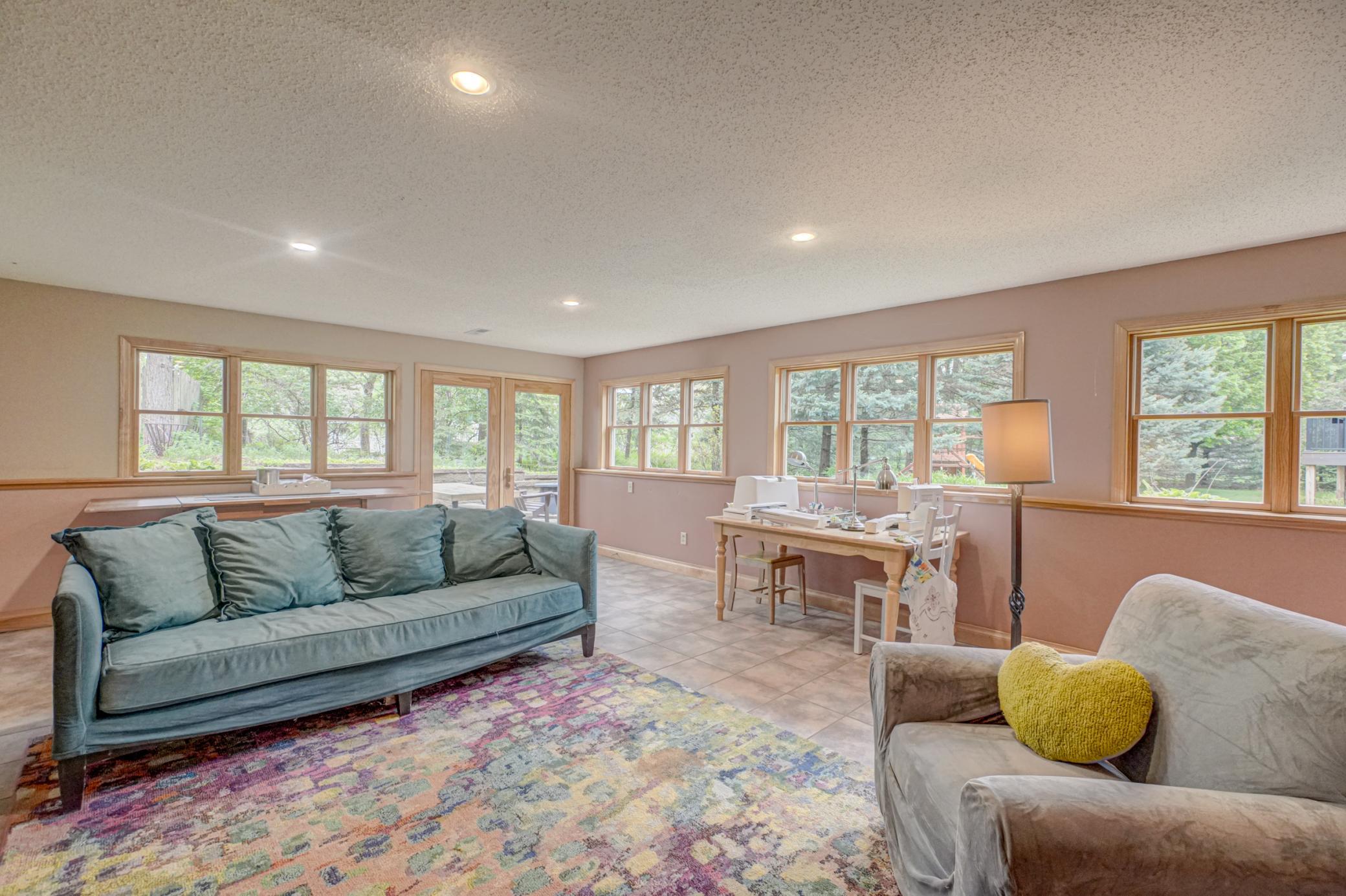 This spacious recreation room features in-floor heat and walls of windows to bring in plenty of natural light.