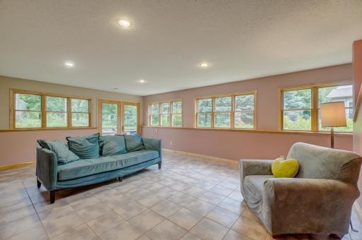 This spacious recreation room features in-floor heat and walls of windows to bring in plenty of natural light.