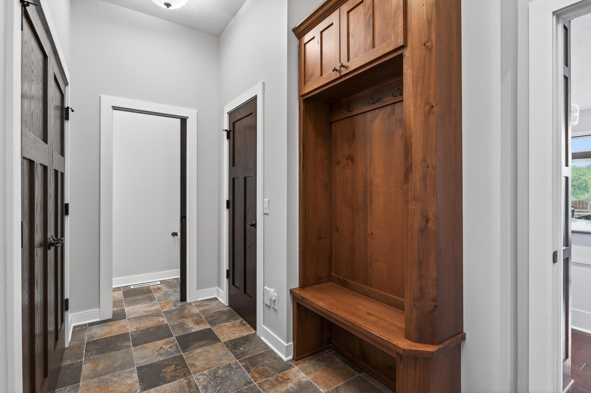 Enter from the garage into a custom mudroom with plenty of storage and a half bath.
