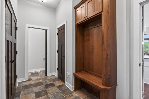 Enter from the garage into a custom mudroom with plenty of storage and a half bath.