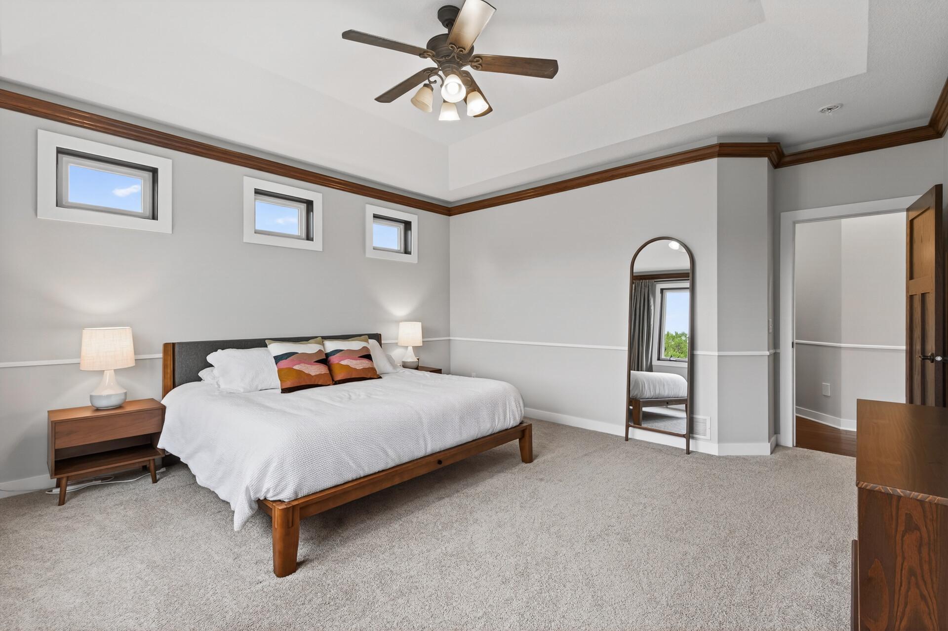 Crown molding with integrated lighting, raised tray ceiling, and plenty of natural light.