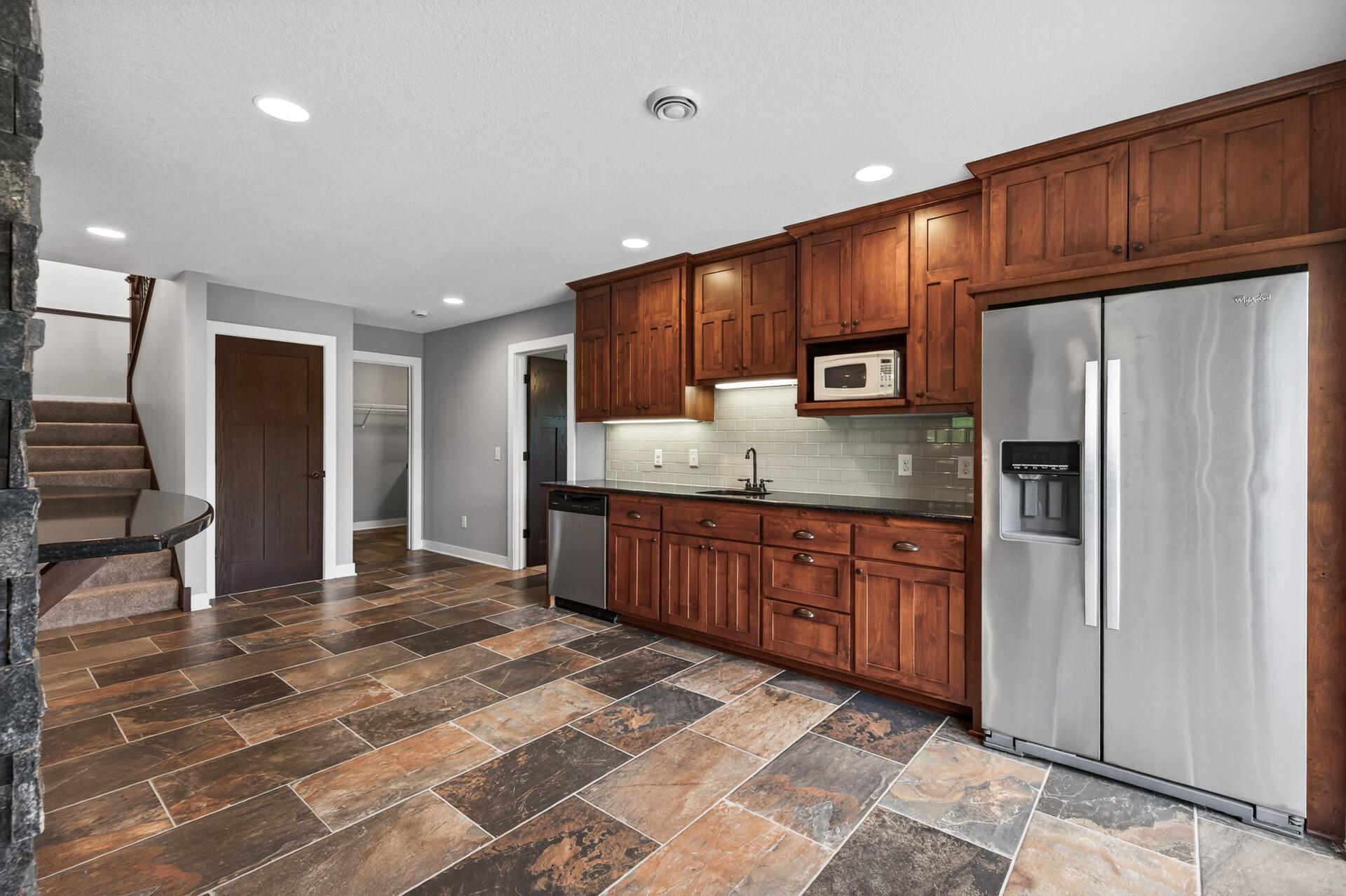 The lower level wet bar with dishwasher, microwave and full sized refrigerator/freezer make entertaining a breeze!